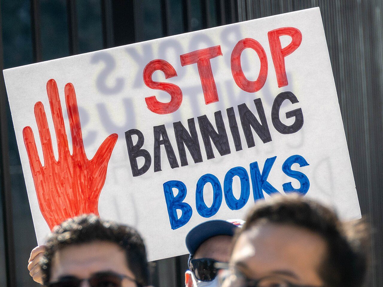 A protester holds a hand-lettered sign reading "Stop Banning Books" at a book-banning protest outside the Georgia State Capitol in Atlanta, February 2022