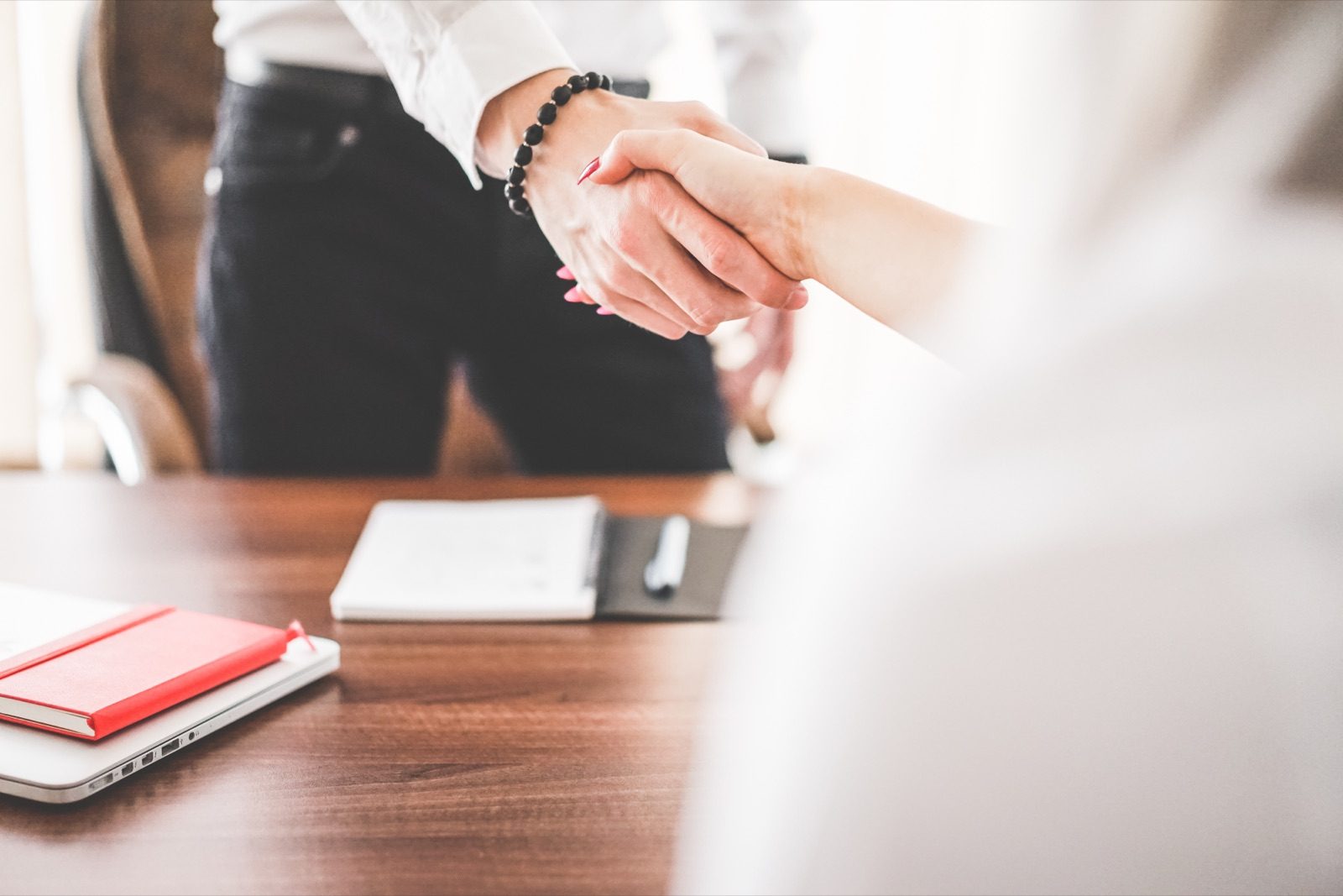 A businessman and businesswoman shaking hands in an office