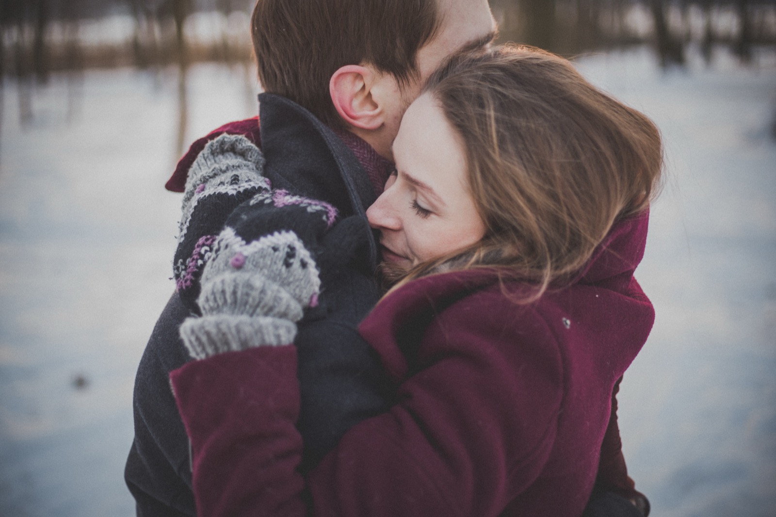A couple hugging outdoors in winter clothing