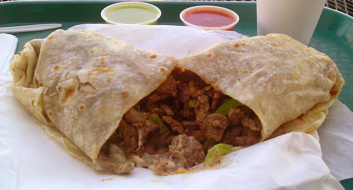 A carne asada burrito from a San Diego-area restaurant, sliced open to show the meat, beans, and rice inside