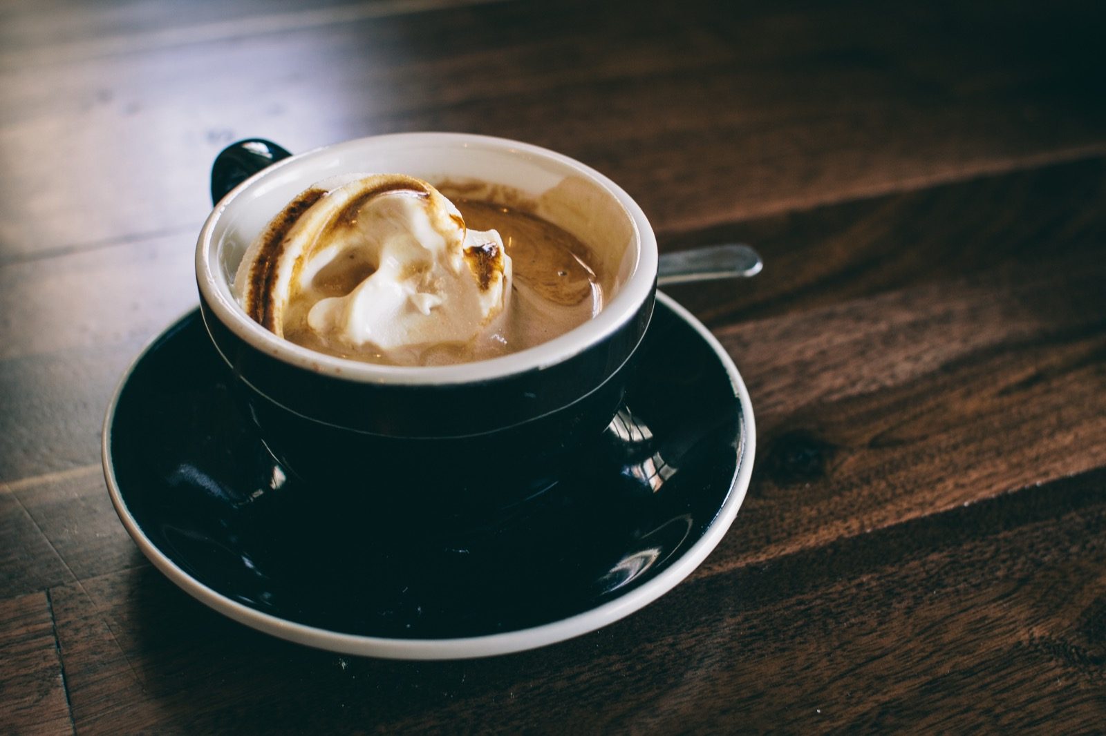 A black cup of coffee on a saucer