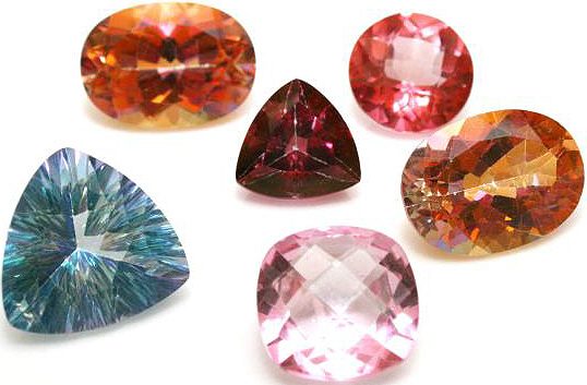 Faceted topaz gemstones in a range of natural colors, from clear to sherry-brown to pink