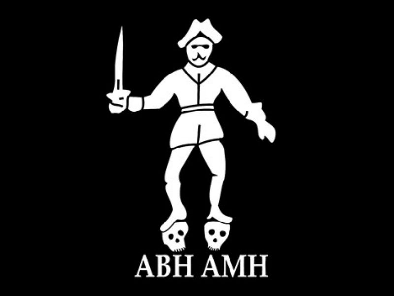 Illustrated black flag reconstruction of pirate Bartholomew Roberts's Jolly Roger, showing a pirate figure standing on two skulls